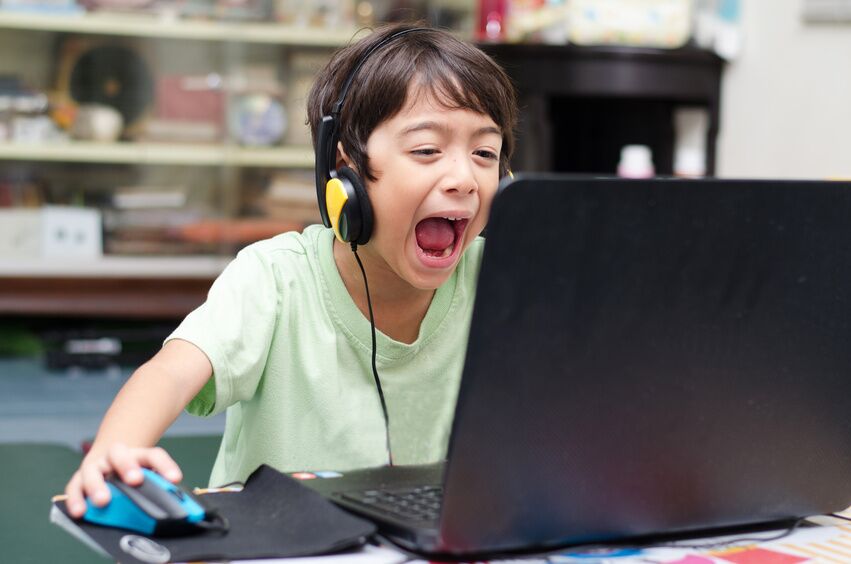 Little boy playing pc game at home